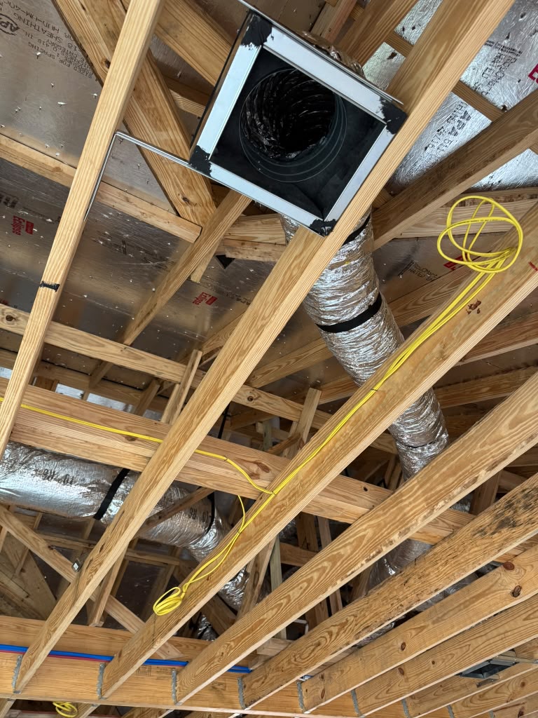 Metal ceiling vent box connected to insulated ductwork and secured between wood joists