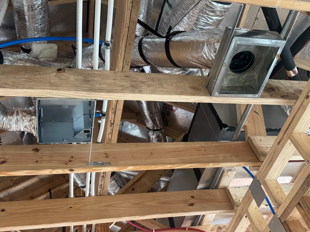 Insulated ductwork and metal vent boxes installed above exposed ceiling framing