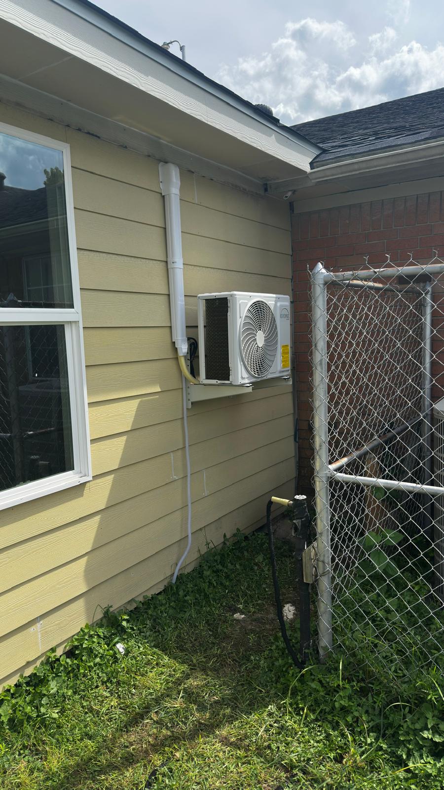Wall-mounted outdoor mini-split unit with covered lines