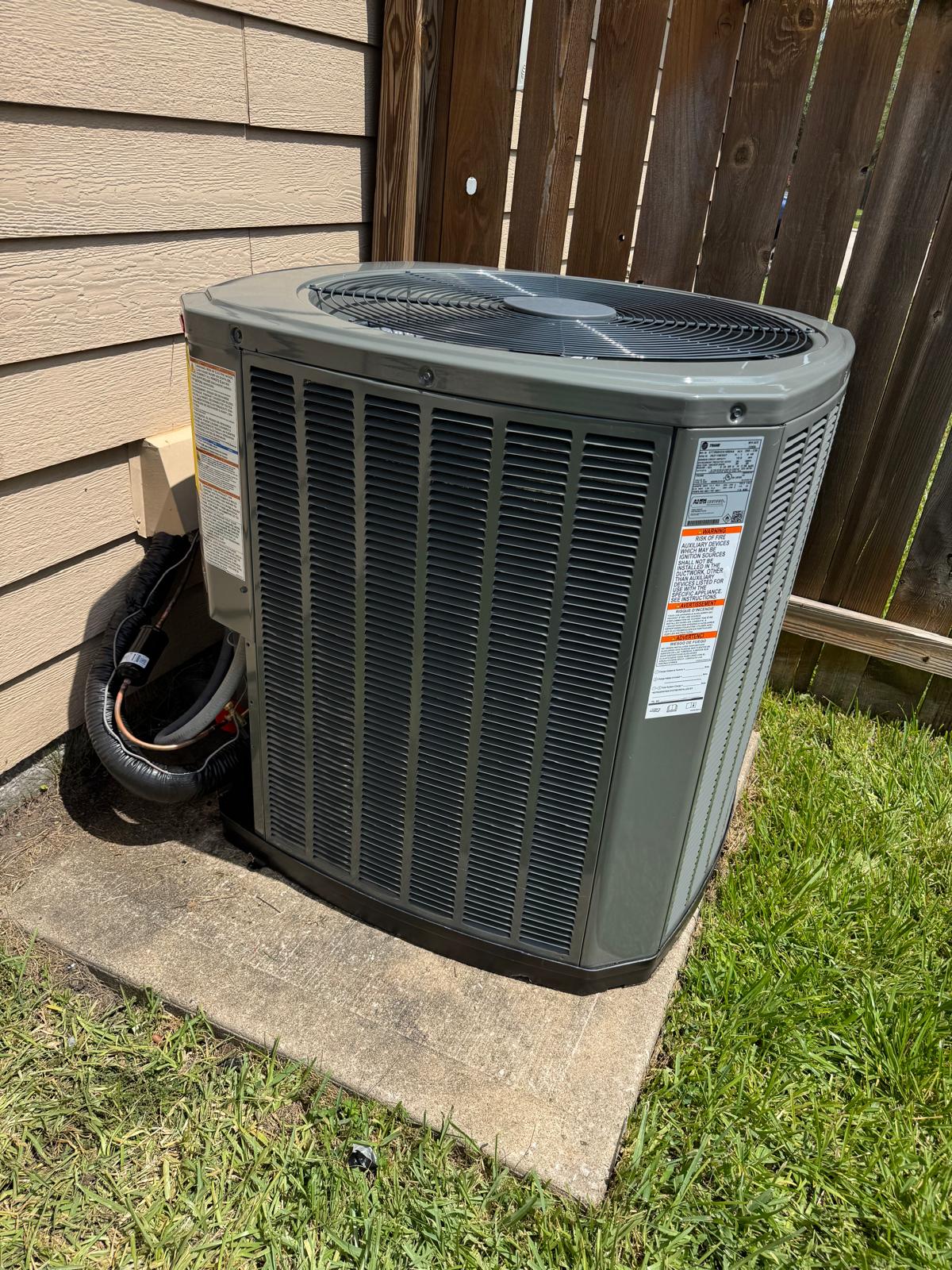 Outdoor air-conditioning condenser on a concrete pad beside a home